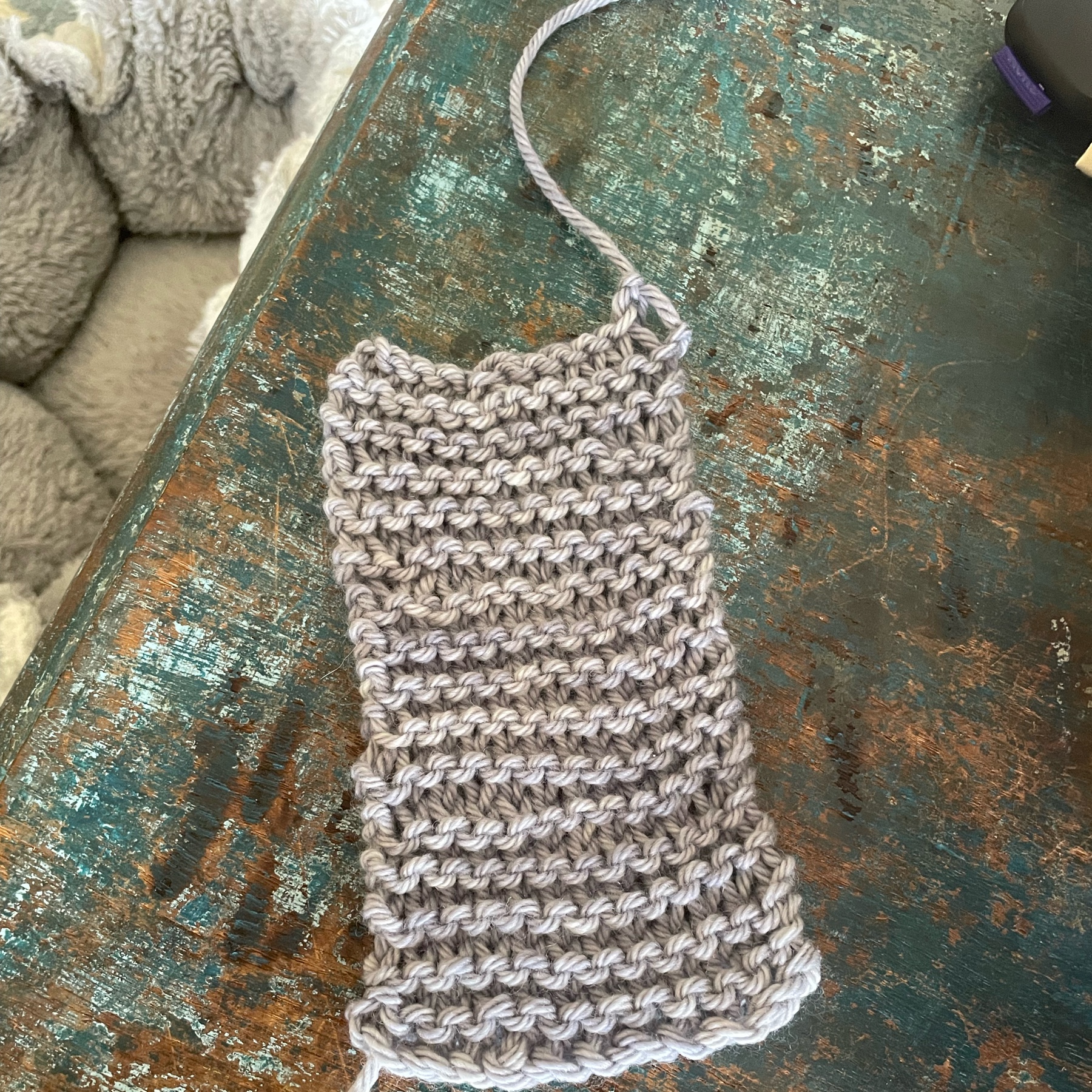 a small knitting project in grey wool